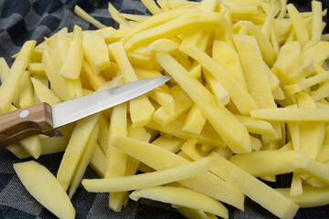 frites fraîches crues sur une planche à découper