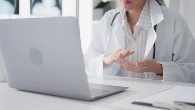 Asian female doctor using laptop computer online video call remote talking to patient, prescribe medicine. Tele medical, telehealth, hospital clinic health care service, or internet technology concept