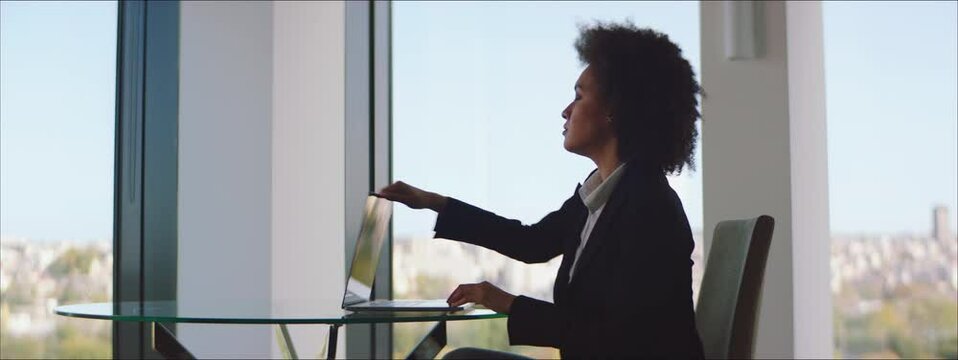 Worried Businesswoman Closing A Laptop Lid And Thoughtfully Looking Through The Window.