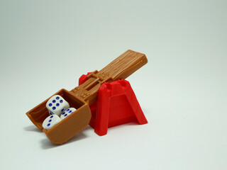 Catapult that throws the dice of destiny.  Catapult. Dices. Toy catapult. Graphic resources. Throw. Isolated white.
