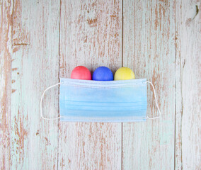easter eggs in protective masks on wooden background