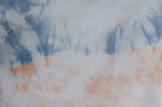 Tie dye fabric in blue and orange pastel colors.