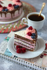 portion of chocolate cake on plate and notebook, cup of coffee