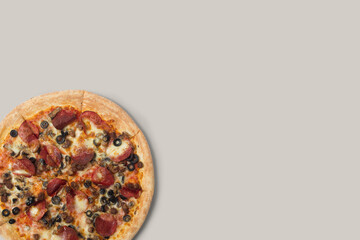 Delicious pizza and ingredients of sausage, bacon and mozzarella on a grey background. Top view of delicious pizza.