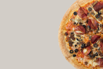 Delicious pizza and ingredients of sausage, bacon and mozzarella on a grey background. Top view of delicious pizza.