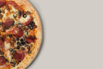 Delicious pizza and ingredients of sausage, bacon and mozzarella on a grey background. Top view of delicious pizza.