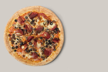 Delicious pizza and ingredients of sausage, bacon and mozzarella on a grey background. Top view of delicious pizza.