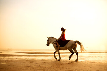 Girl riding a horse on the background of the sea