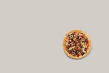 Delicious pizza and ingredients of sausage, bacon and mozzarella on a grey background. Top view of delicious pizza.