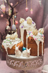 Traditional cupcake Easter cake kulich with raisins on dark purple background. homemade cake with dried fruits. Easter bunnies  Easter decoration table. easter desert celebration. 
