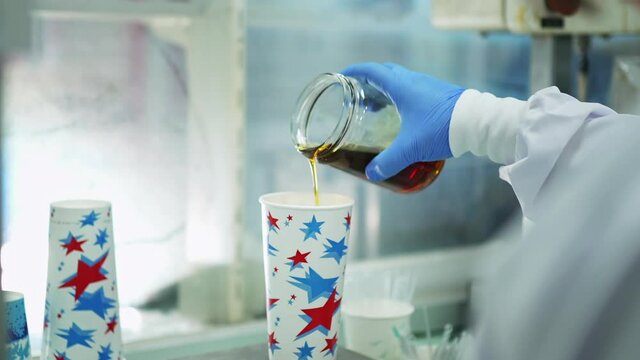 Scientist with Blue Gloves and White Shirt doing Experiments with Golden Liquid in Chemical Laboratory of Polyurethane Factory in slowmo