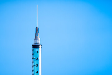 syringe on blue background. Vaccine preventions. Detail. Copy space
