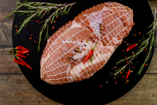 Boneless Pork Shoulder With Spices On Black Wooden Board.