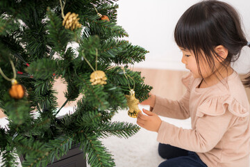 クリスマスの飾り付けをする女の子