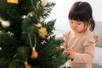 クリスマスの飾り付けをする女の子