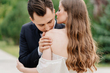 beautiful, gentle and happy bride and groom. man gently kisses woman's shoulder