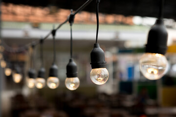 Fototapeta na wymiar Selective focus of Decorative bulbs in cafes on background blurred