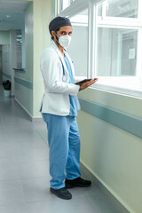 Fototapeta premium Doctor checking his tablet in the corridor of a hospital