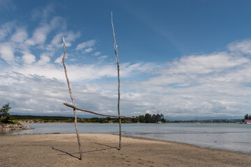 Makeshift rugby goalposts on the beach at the Waimea Inlet at low tide in the late afternoon. Mapua, New Zealand.