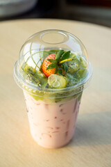 Strawberry on a glass with ice topped with green tea.