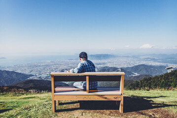 Naklejka na ściany i meble 天空のベンチに座る男性 香川県