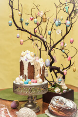 Fototapeta na wymiar Special easter cake Kulich with the Easter eggs and decorations on a yellow backdrop. Happy easter food and decorations 