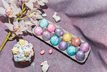 Obraz na płótnie Canvas Special easter cake Kulich with the remit and dyed eggs. Cosmos painted eggs with white rabbits. Easter composition
