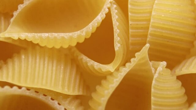 Pasta for food, rotation. Macaroni - Mini Conchiglie Rigate close up.