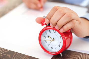 The alarm clock in front of the desk during the exam