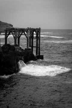 Olas del mar contra muelle antiguo y dique en la costa en Tenerife