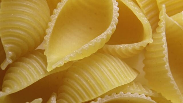 Pasta for food, rotation. Macaroni - Mini Conchiglie Rigate close up.