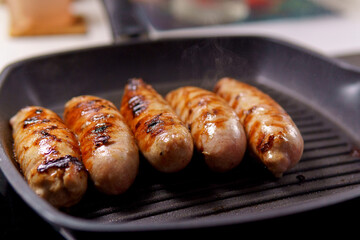 homemade juicy grilled sausages on a grill pan selective focus. Cooking food