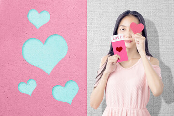 Asian woman holding the pink envelope with love text and a red heart