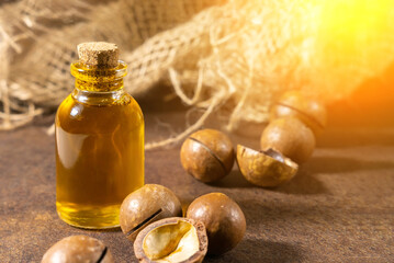 Ripe macadamia nuts and a glass bottle with natural oil Source of natural. Selective focus.