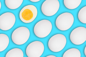 Seamless pattern of whole and one cut white Easter eggs on a blue background