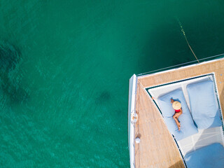 A woman sunbathing on a  catamaran boat