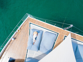 A woman sunbathing on a  catamaran boat