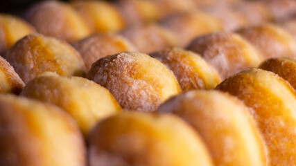 close up of a pile of doughnut with icing sugar 