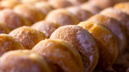 close up of a pile of doughnut with icing sugar 