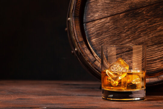 Scotch whiskey glass and old barrel