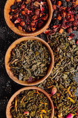 Wooden bowls with different sorts of dry tea leaves