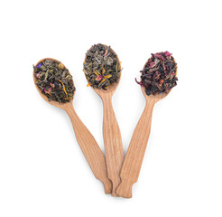 Wooden spoons with dry tea leaves and flowers on white background