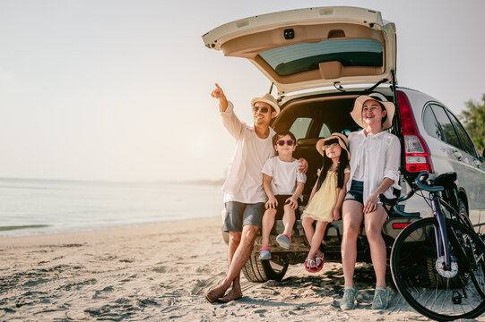 Happy Asian Family Enjoying Beach Trip With Their Favorite Car. Parents And Children Are Traveling The Way To The Sea.Holiday And Travel Family Concept, Summer Vacations.