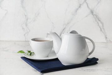 Obraz na płótnie Canvas Teapot and cup of tea on light background