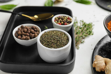 Tray with different spices and herbs on light background