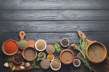 Obraz na płótnie Canvas Different spices and herbs on dark wooden background