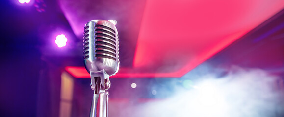 Close-up old retro vintage microphone on blurred stand up smoke background concert banner
