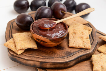 Composition with delicious homemade plum jam on wooden background