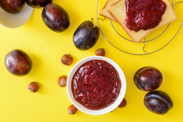 Composition with delicious homemade plum jam on color background