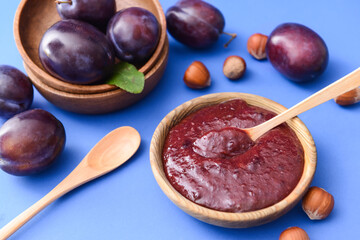 Bowl with delicious homemade plum jam on color background